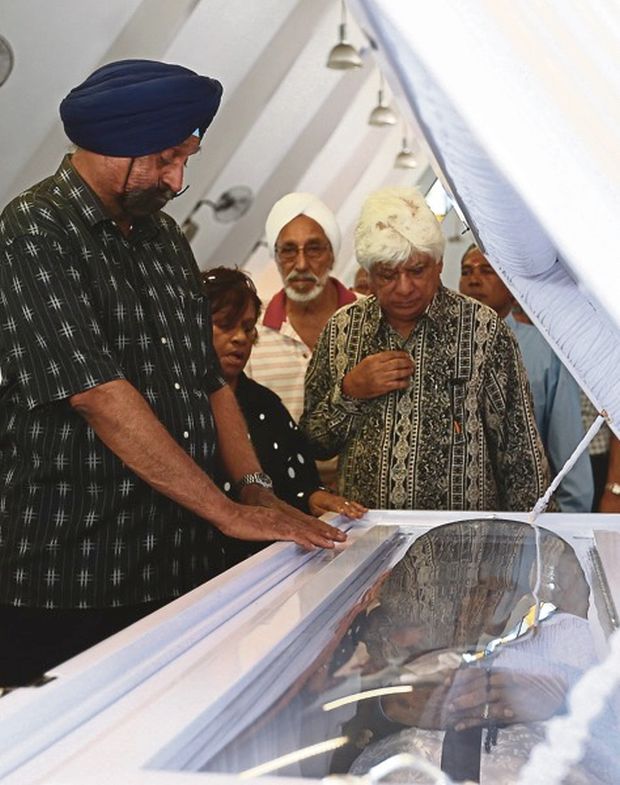 Former Johor and national cricketer Datuk Dr Harjit Singh (left), Gurucharan (third left) and Yogeswaran paying their last respects. u00e2u20acu201d Malay Mail pic