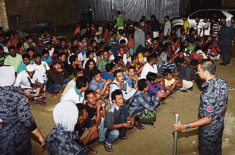 Immigration Department officers keep an eye on foreigners without proper documents in an operation in Putrajaya on Saturday. u00e2u20acu00a8u00e2u20acu201d Bernama pic