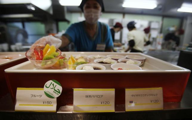 File picture shows a staff showing a bowl of cut fruit, above a 'u00e2u20acu2122halal certifiedu00e2u20acu2122 sign, at a dining hall in the Kanda University of International Studies in Chiba, Japan, May 13, 2014. u00e2u20acu201d Reuters pic