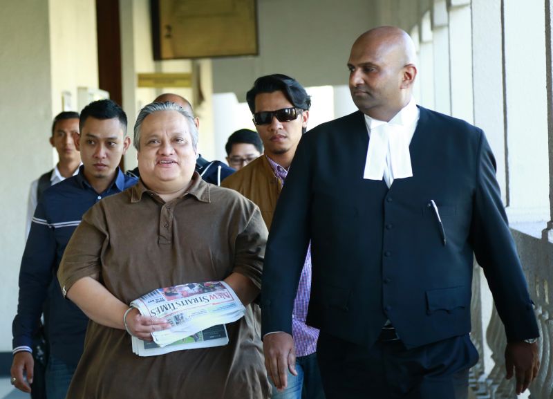 Harzani Azmi (left) with his lawyer outside the courtroom where he claimed trial to two counts of fraud and money laundering. u00e2u20acu201d Picture courtesy of MACC
