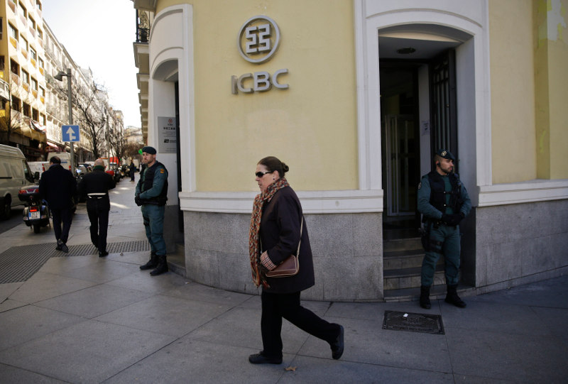 Spanish civil guards stand in front of the entrance of the headquarters of Industrial and Commercial Bank of China (ICBC) as people walk by during a raid in Madrid, Spain, February 17, 2016. u00e2u20acu201d Reuters pic