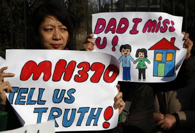 Catherine Gang, whose husband Li Zhi was onboard the missing Flight MH370, holds a sign during a gathering of family members of the missing passengers outside the Malaysian embassy in Beijing March 8, 2015. u00e2u20acu201d Reuters pic
