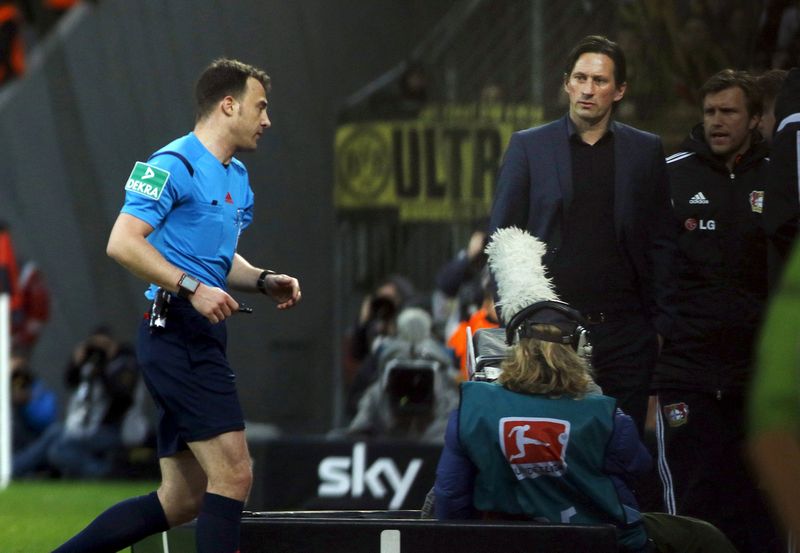 Referee Felix Zwayer walks to Leverkusen's coach Roger Schmidt (right) in the German Bundesliga match at Leverkusen, February 21, 2016.  u00e2u20acu201d Reuters pic