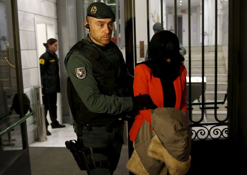 A suspect is led by a Spanish Civil Guard officer as they leave the headquarters of Industrial and Commercial Bank of China during a raid in Madrid, February 17, 2016. u00e2u20acu201d Reuters pic
