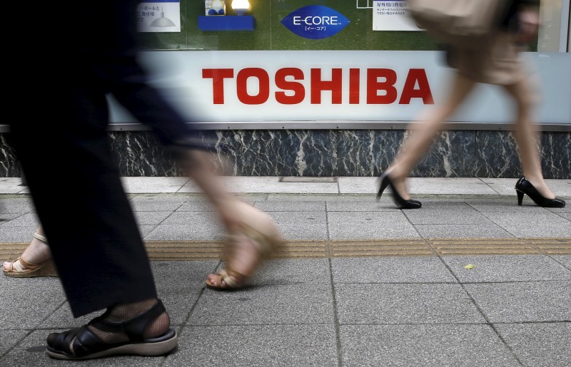 Pedestrians walk past a logo of Toshiba Corp outside an electronics retailer in Tokyo September 14, 2015. u00e2u20acu201d Reuters picn