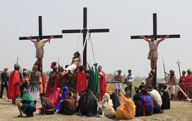 Ruben Enaje (centre), who is portraying Jesus Christ for the 30th time, is pulled down by residents acting as Roman soldiers during a Good Friday crucifixion re-enactment in Cutud town, Philippines, March 25, 2016. u00e2u20acu201d Reuters picn