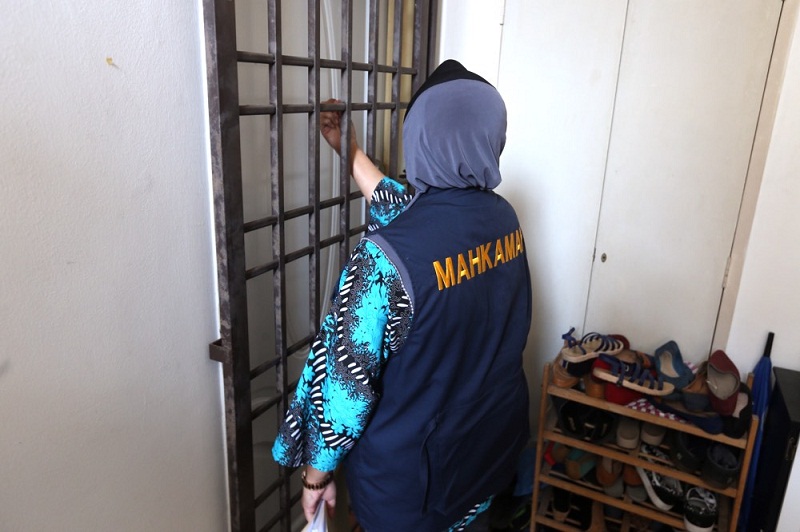 A court bailiff posts the notice of seizure and sale for an apartment property under Papagomou00e2u20acu2122s real name, Wan Muhammad Azri Wan Deris, in Kuala Lumpur March 14, 2016. u00e2u20acu201d Picture by Choo Choy May
