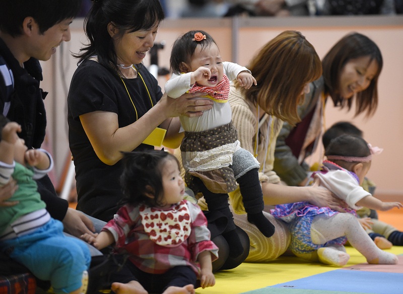 A mother tries to put her crying baby on the starting line during the Baby Super Crawl Dash at an event for young parents in Yokohama, in suburban Tokyo, on November 23, 2014. u00e2u20acu201d AFP pic
