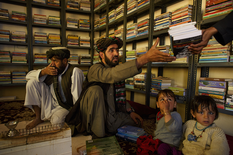 Matiullah Wesa, his brother, Atta Muhammad and Wesau00e2u20acu2122s nieces inside the library Wesa established three years ago in their family home in Spin Boldak, Afghanistan, February 10, 2016. u00e2u20acu201d Picture by Andrew Quilty/The New York Timesn