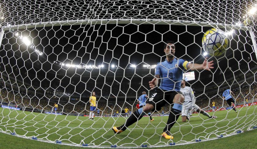 Luis Suarez of Uruguay picks up the ball after his teammate Edinson Cavani (22) scored a goal against Brazil at the World Cup Qualifiers in Recife, March 26, 2016. u00e2u20acu201d Reuters pic