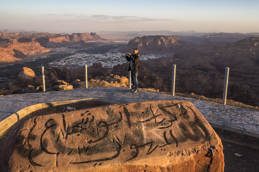 A tourist takes a photograph from one of the mountains that overlooks the city of Al-Ula, Saudi Arabia, March 7, 2016. — Picture by Bryan Denton/The New York Times