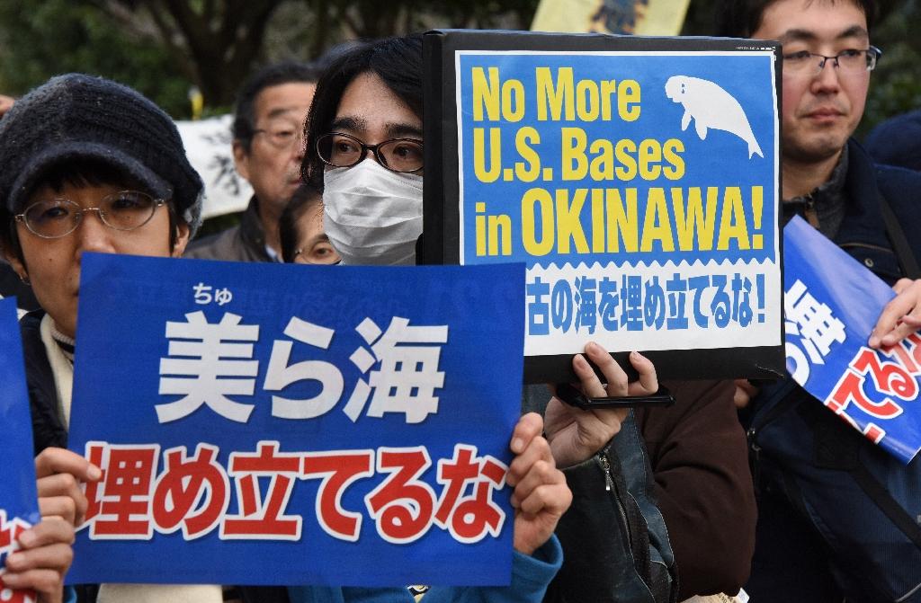 People hold banners at a rally against a new US military base in Okinawa, in Tokyo on February 21, 2016. u00e2u20acu201d AFP 