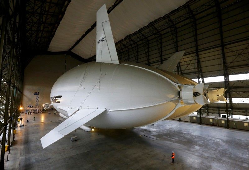 A worker stands under the Airlander 10 hybrid airship during its unveiling in Cardington, Britain March 21, 2016.  u00e2u20acu201d Reuters pic