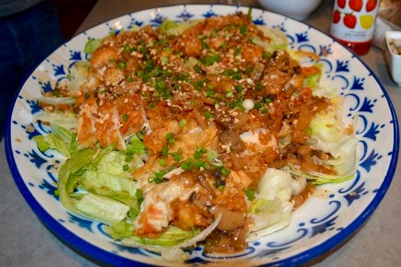 The almond boneless chicken dish is served on a bed of iceberg lettuce and topped with mild brown gravy, toasted almonds and a sprinkling of green onions. u00e2u20acu2022 Reuters pic