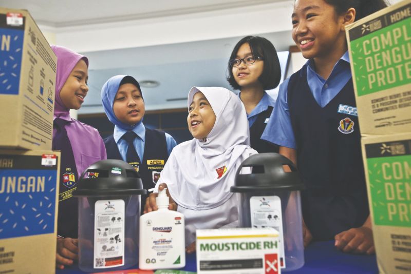 Schoolchildren with the contents of the anti-dengue home kit during the presentation ceremony yesterday. u00e2u20acu201d Picture by Azneal Ishak