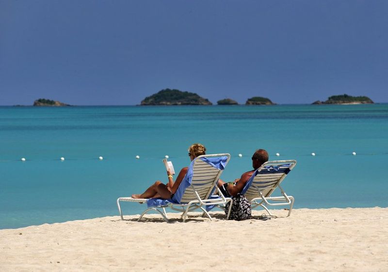 A couple sunbathe at a beach in St John's, Antigua, a onetime British colony nestled in the middle of the West Indies. u00e2u20acu2022 AFP pic