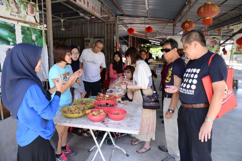 Interpreter Siti Zubaidah Mohd Lani (left)interprets for the group of blind, deaf and deaf blind at the Ghee Hup Nutmeg Factory. u00e2u20acu2022 Picture by K.E.Ooi