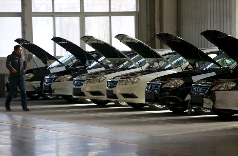 A man walks past cars at an assembly line producing electronic cars at a factory of Beijing Electric Vehicle, funded by BAIC Group, in Beijing, China, January 18, 2016. u00e2u20acu201d Reuters pic