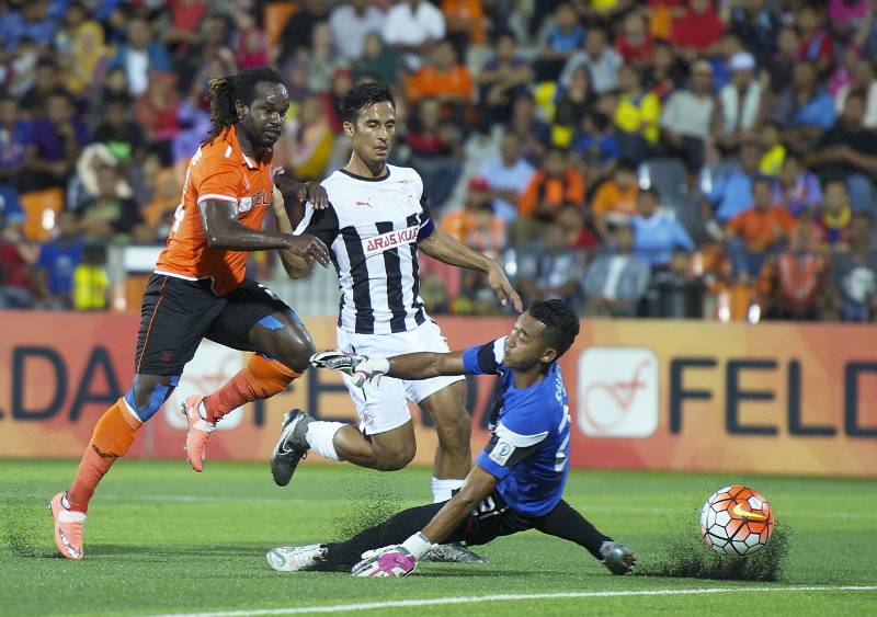 Penyerang Felda United Francis Forkey Doe (kiri) berjaya melepaskan rembatan menewaskan penjaga gol Pahang Muhamad Saufi ketika perlawanan Liga Super di Stadium Tun Abdul Razak (STAR), Jengka, Maran 12 Mac 2016. u00e2u20acu201d Foto Bernama