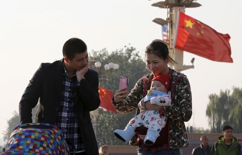 A couple takes pictures with their baby on the Tiananmen Gate in Beijing November 2, 2015. u00e2u20acu201d Reuters pic
