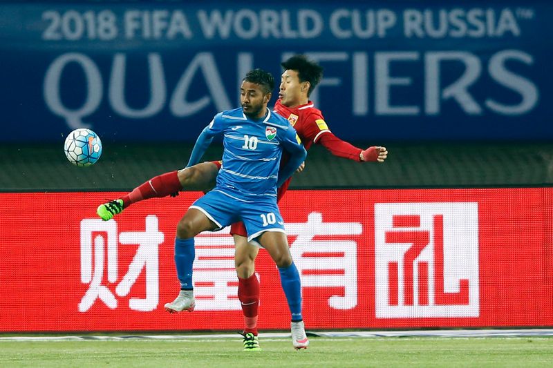 Jiang Ning of China (right) competes for the ball with Ismail Easa of Maldives during their World Cup football qualifying match in Wuhan March 24, 2016. u00e2u20acu201d AFP pic