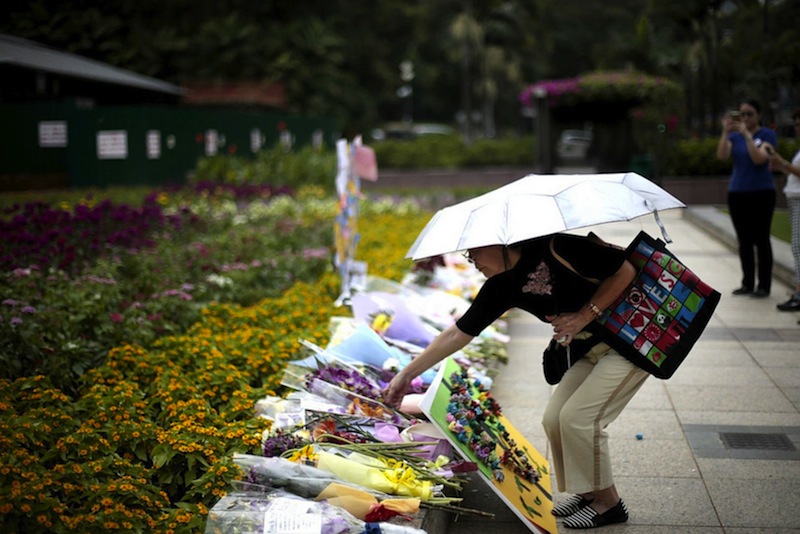 A woman placing flowers at the Lee Kuan Yew tribute site at Istana Park yesterday. u00e2u20acu201du00c2u00a0TODAY picture by Jason Quah