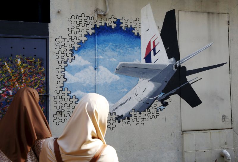 Women look at a mural of missing Malaysia Airlines flight MH370 two years after it disappeared, in Kuala Lumpur, March 8, 2016. u00e2u20acu2022 Reuters pic