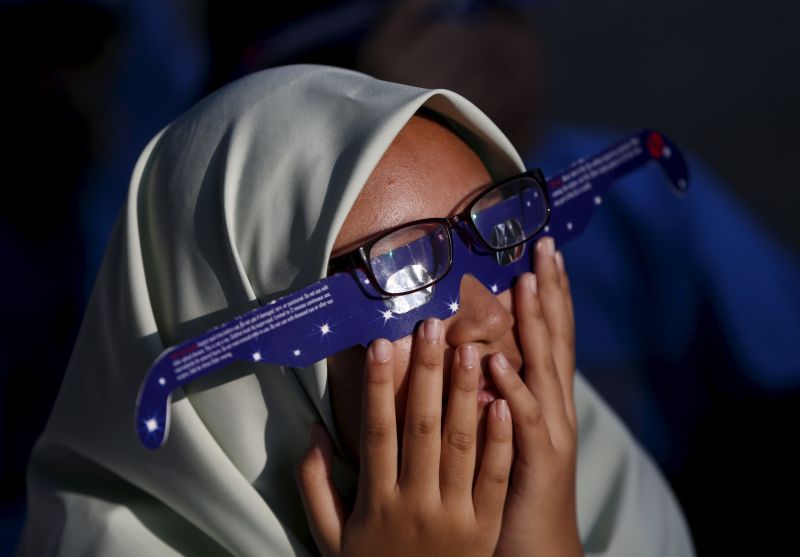 A school girl watches a partial solar eclipse at the Planetarium in Kuala Lumpur, Malaysia, March 9, 2016. u00e2u20acu2022 Reuters pic
