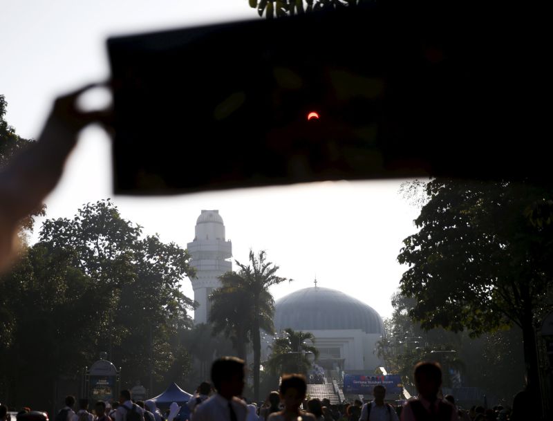 A student holds filter paper to watch the partial solar eclipse at the Planetarium in Kuala Lumpur, Malaysia, March 9, 2016. u00e2u20acu2022 Reuters pic