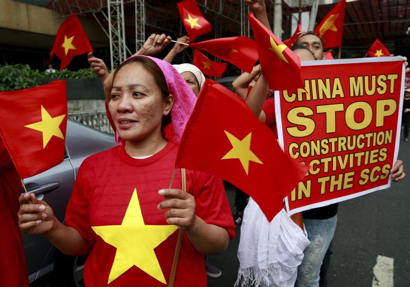 Protesters wave Vietnamese flags and hold a placard as they denounce China's military buildup in the South China Sea in front of the Chinese Consulate in Manila February 25, 2016. u00e2u20acu201d Reuters pic 