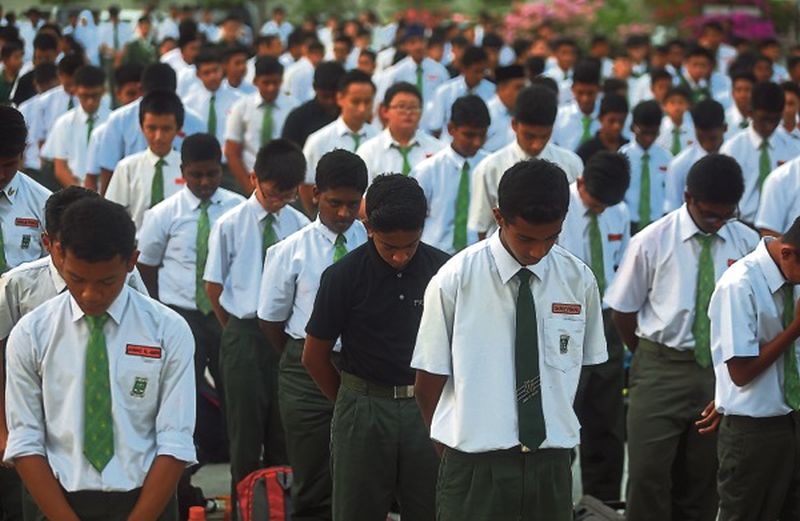 Hundreds of students and teachers observed a minute's silence to remember and express gratitude to Vincent. u00e2u20acu2022 Picture by Farhan Najib