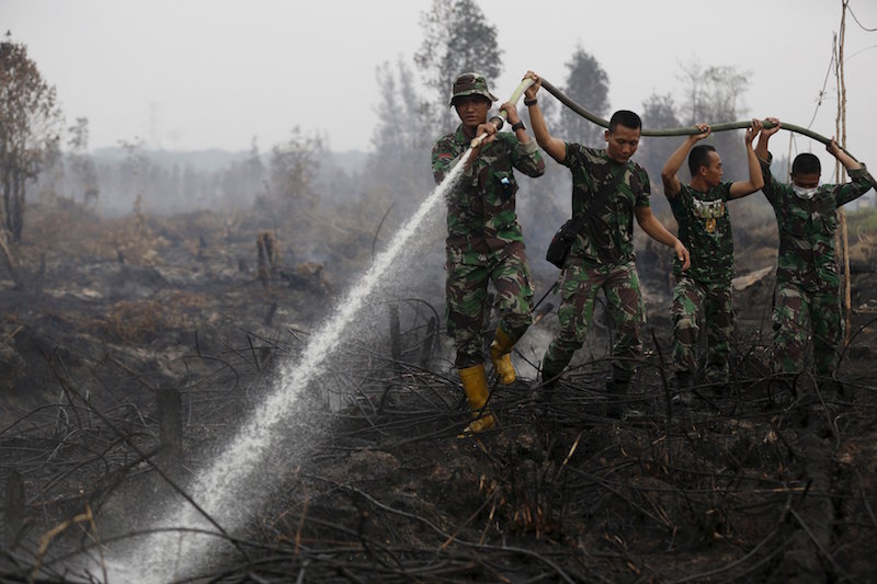 Indonesian soldiers spray water on peatland fire in Pulang Pisau regency east of Palangkaraya, Central Kalimantan, Indonesia in this October 29, 2015 file photo. u00e2u20acu201d Reuters picn