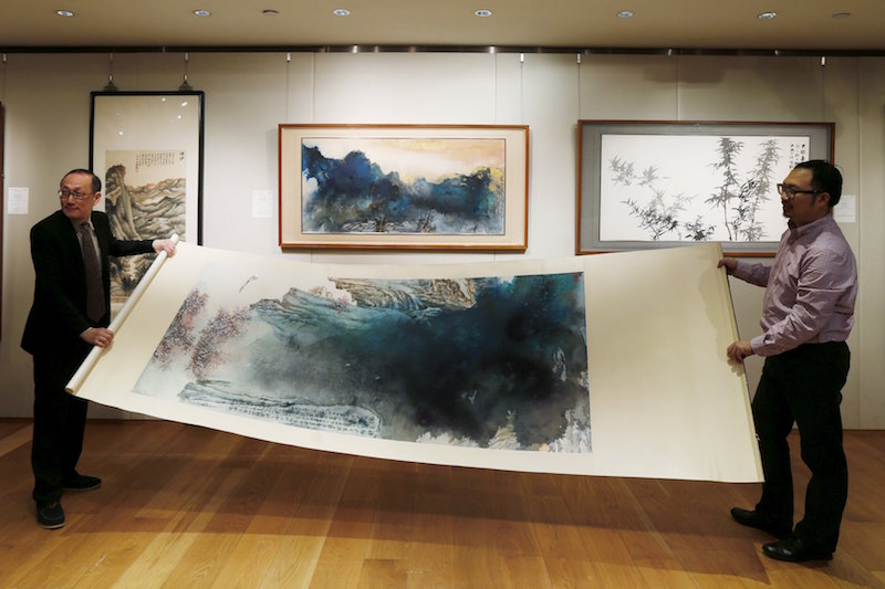 An inkbrush painting by late Chinese artist Zhang Daqian called u00e2u20acu02dcPeach Blossom Springu00e2u20acu2122 is rolled during a preview at Sothebyu00e2u20acu2122s in Hong Kong, China, in this March 10, 2016 file photo. u00e2u20acu201d Reuters picn