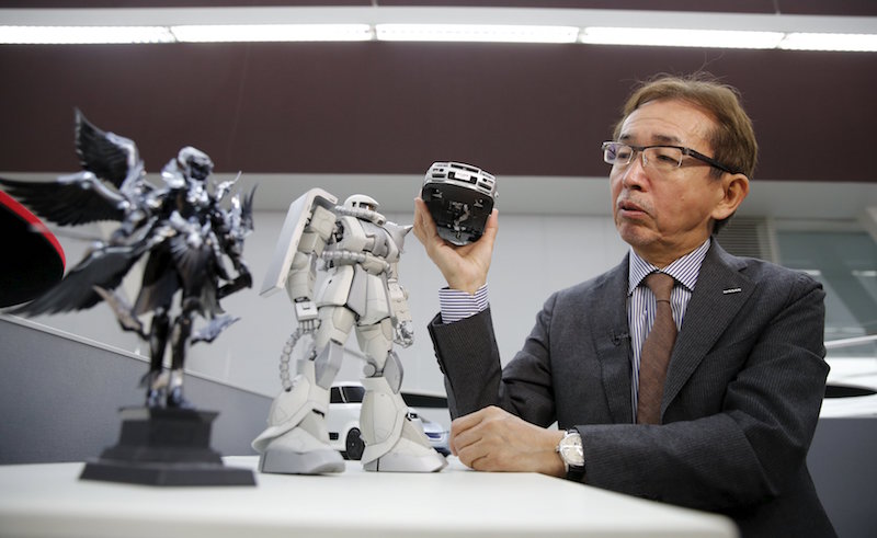 Shiro Nakamura, Senior Vice President and Chief Creative Officer of Nissan Motor Co, holds a model of Nissan Skyline GT-R supercar as he speaks to Reuters next to a model of ‘Zaku’ character from Japan’s popular robot animation series Gundam, at the company’s Global Design Centre in Atsugi, Japan, April 14, 2016. — Reuters pic