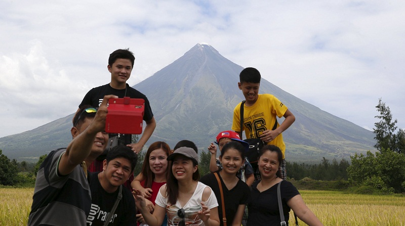 Tourists take selfie in front of Mayon volcano in Daraga, Albay in central Philippines April 4, 2016. u00e2u20acu201d Reuters pic