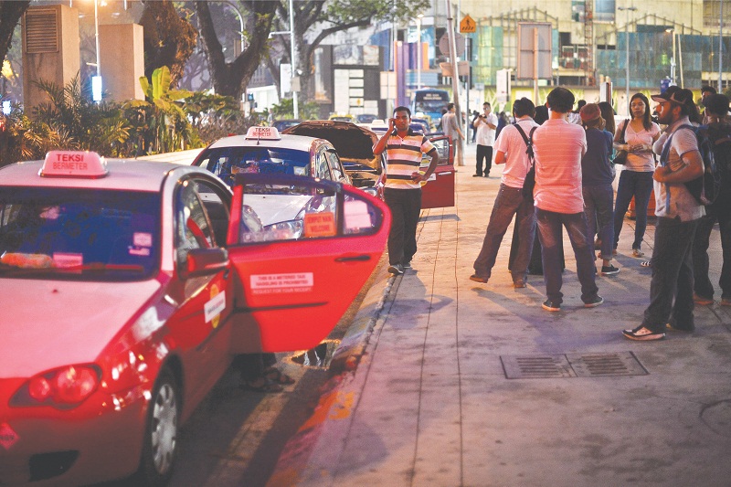 Taxis line up at KLCC while waiting for passengers. Uber and GrabCar drivers say protests by cabbies will be detrimental to the industry. u00e2u20acu201d Picture by Malay Mail