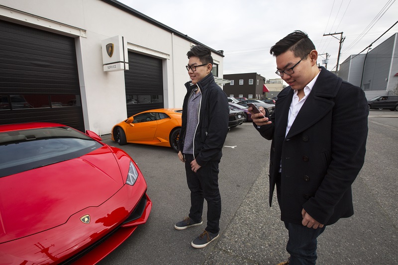 Andy Guo (left) and his twin brother, Anky Guo, with the red Huracan Lamborghini they co-own, at a dealership reception in Vancouver, British Columbia, Canada, March 19, 2016. Vancouver is home to many wealthy Chinese, whose presence some say has caused an affordable housing crisis. — Picture by Ruth Fremson/The New York Times