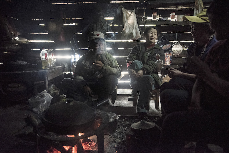 Ethnic Dulong sit around a fire drinking baijiu, a type of liquor, in the morning in Pukawang's old village near the Green Cottage, near Kongdang, China, April 3, 2016. — Picture by Gilles Sabrie/The New York Times