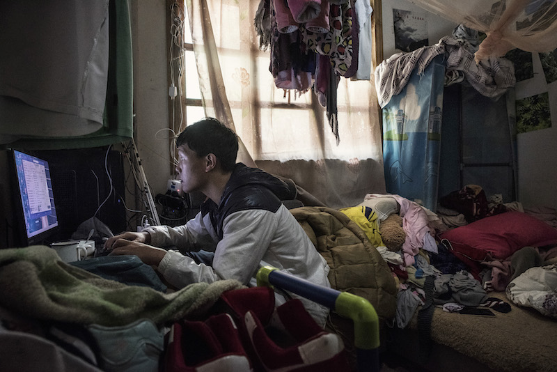 Kong Mingqing on the Internet in his family's modern house, provided by the government as part of a poverty alleviation project, in the Yunnan province of China, April 3, 2016. u00e2u20acu201d Picture by Gilles Sabrie/The New York Times