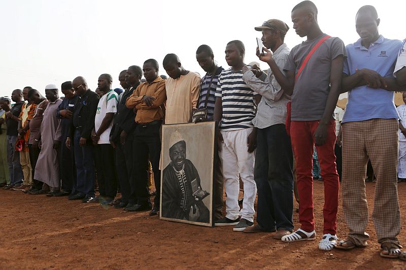 Men pray in front of a painting of late photographer Malick Sidibe during an official ceremony commemorating him in Bamako, Mali, April 16, 2016. u00e2u20acu201d Reuters pic