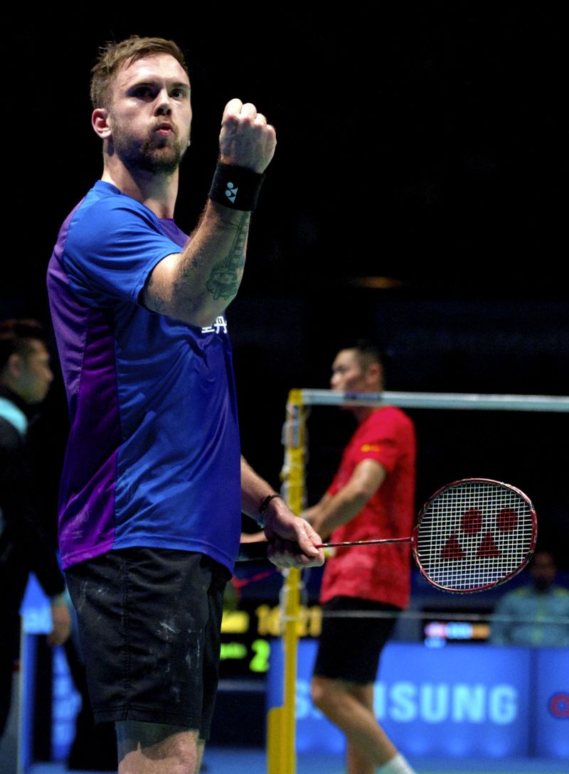 Jan O Jorgensen triumphant as Lin Dan (in background) walks off, claiming distraction of umpire’s decisions. — Bernama pic