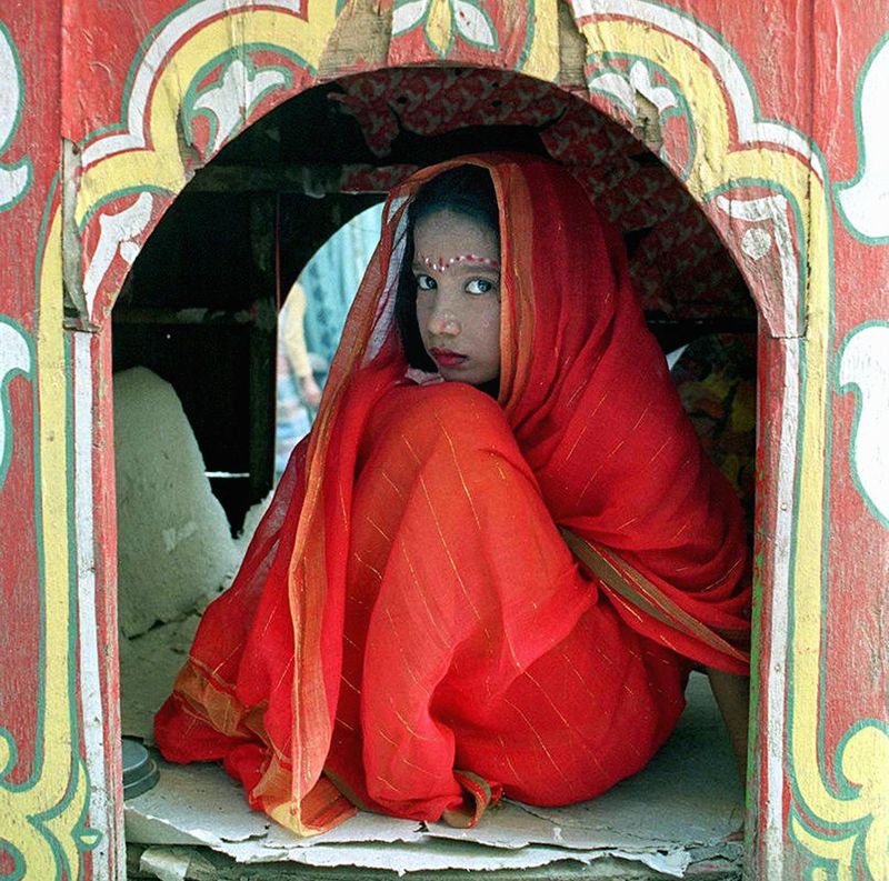 A Bangladeshi girl looks from a decorated window of a float as she is dressed like a wife in a traditional marriage ceremony during a parade in the capital of Dhaka December 29, 2000. u00e2u20acu201d AFP pic
