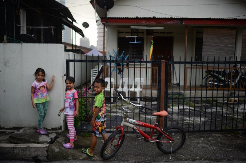 Children play near their house in Kampung Baru, Kuala Lumpur, March 22, 2016. — AFP pic