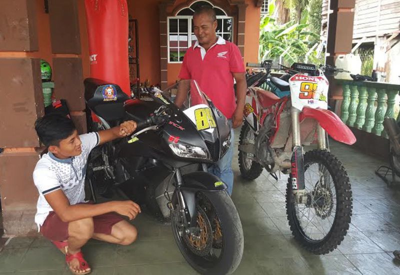Bapa jaguh lumba Pawi Omar, 52, bersama anak keempatnya Khairul Anuar, 16, menunjukkan motosikal milik pelumba negara Khairul Idham ketika melakukan latihan di Kampung Gajah, Perak. u00e2u20acu201d Foto Bernama    
