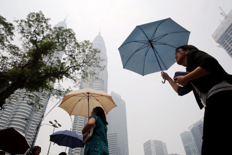 People are seen carrying umbrellas to shield themselves from the sun outside KLCC in Kuala Lumpur, April 22, 2016. u00e2u20acu2022 Picture by Choo Choy May