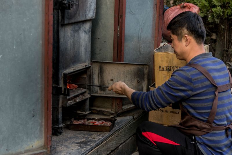A worker stokes the coals at Gyeongsong Yanggochi, the oldest lamb restaurant on the block. 