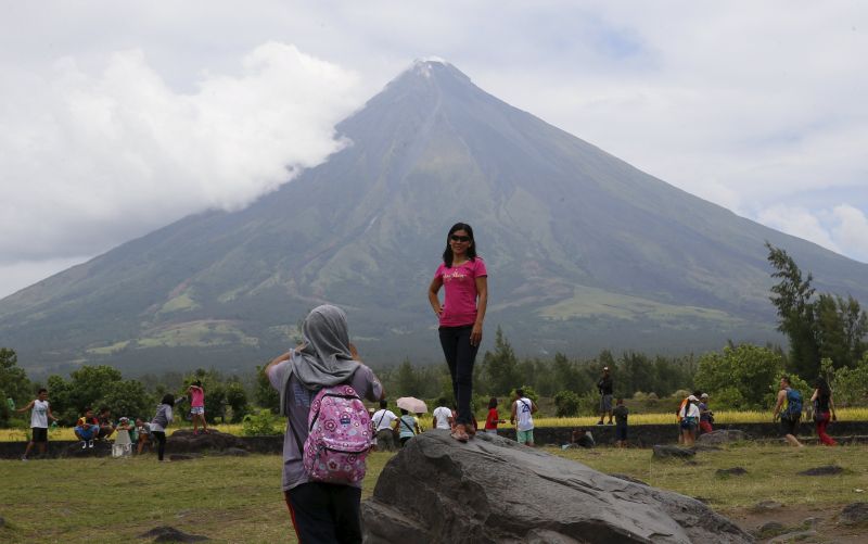 A local tourist poses in front of Mayon volcano in Daraga, Albay in central Philippines April 8, 2016. u00e2u20acu2022 Reuters pic