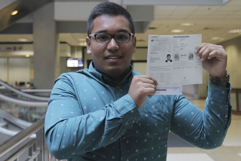 Navin Moorthy who received his citizenship certificate yesterday, shows his temporary IC document in Putrajaya, April 6, 2016. u00e2u20acu2022 Picture by Yusof Mat Isa 