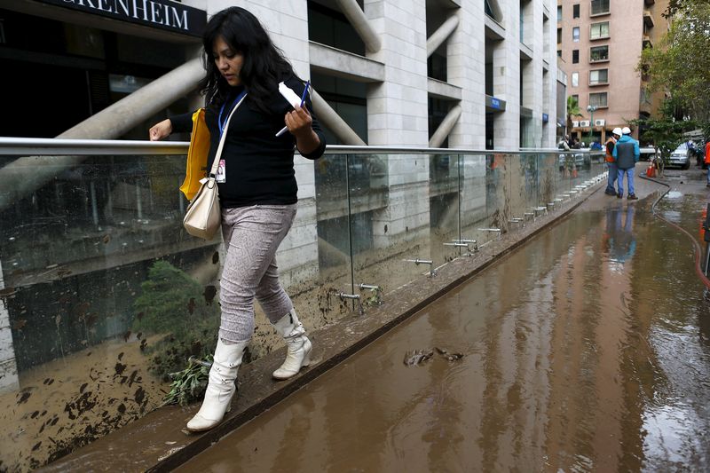A woman walks near a building after a flood in Santiago April 18, 2016. u00e2u20acu201d Reuters pic