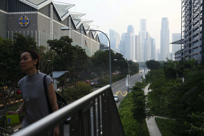 A woman takes a pedestrian bridge in the backdrop of the city skyline shrouded by haze in Singapore March 31, 2016. u00e2u20acu201d Reuters pic
